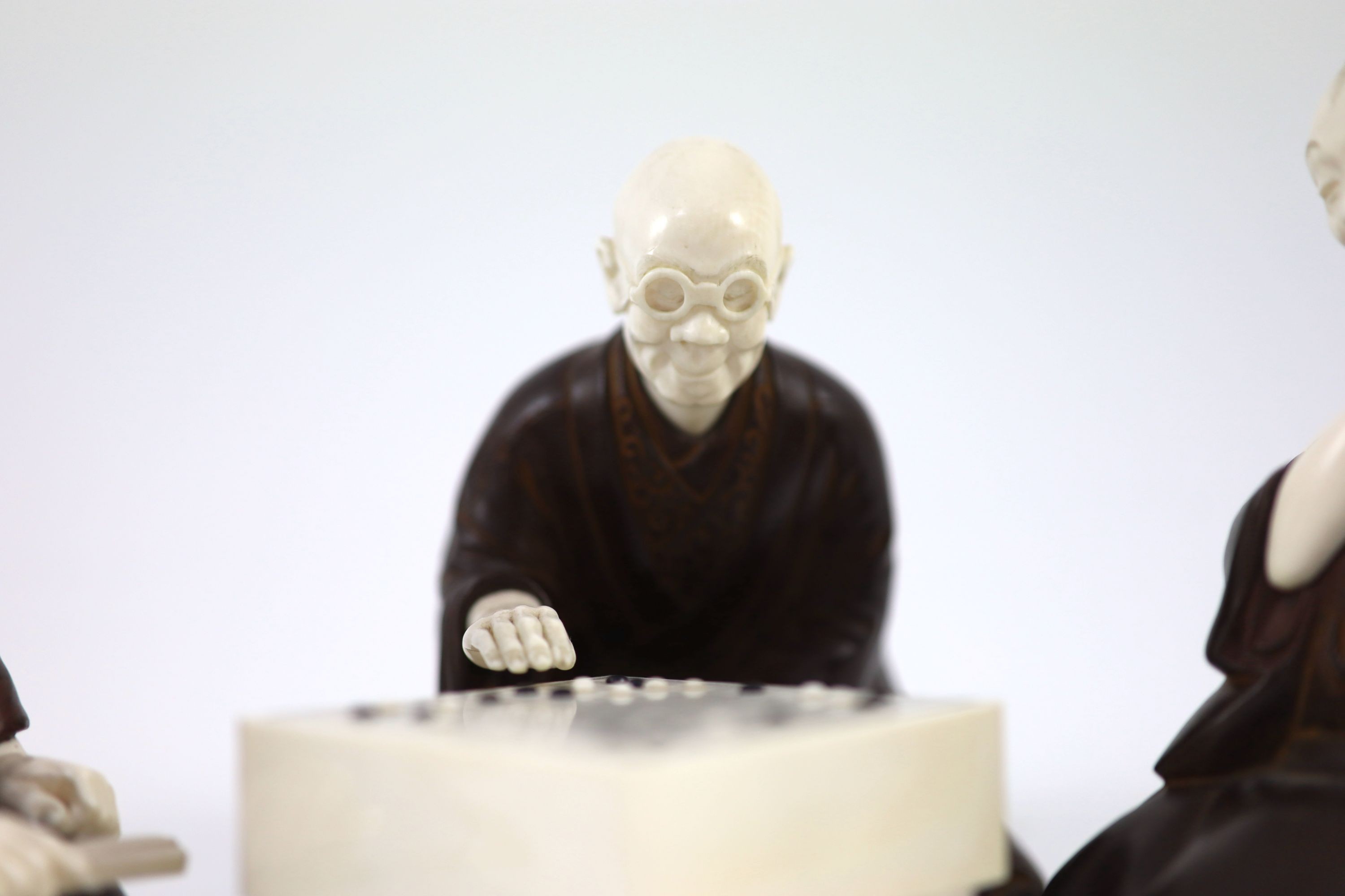A set of three Japanese bronze and ivory okimono of ‘Go’ players, Meiji period,